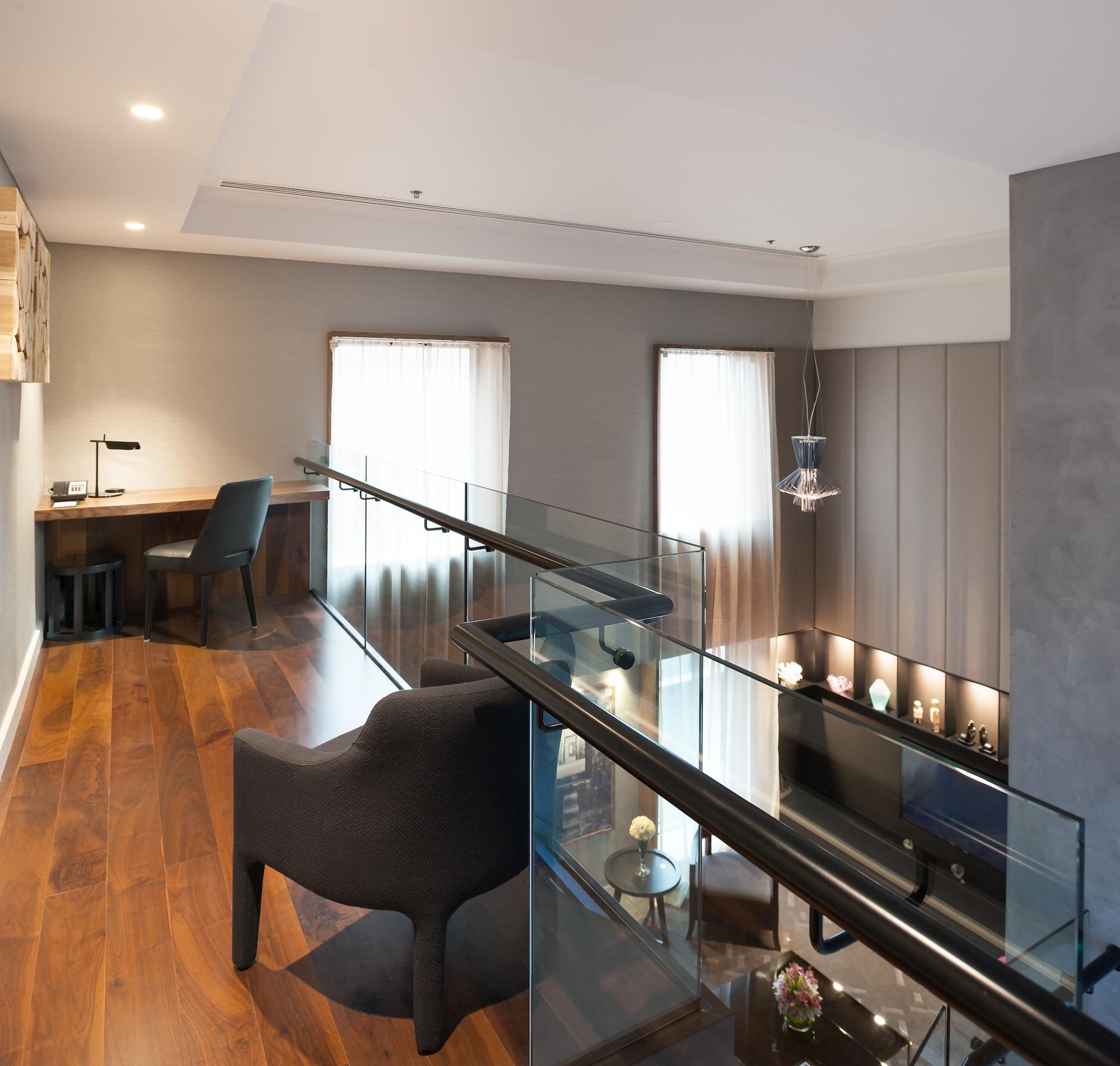 Stamford Plaza Melbourne Ξενοδοχείο Εξωτερικό φωτογραφία The photo shows a modern interior space, featuring a second-floor balcony overlooking a lower level. The decor is stylish and minimalistic, with a combination of wooden flooring and neutral-colored walls. 

On the upper level, there is a small desk a