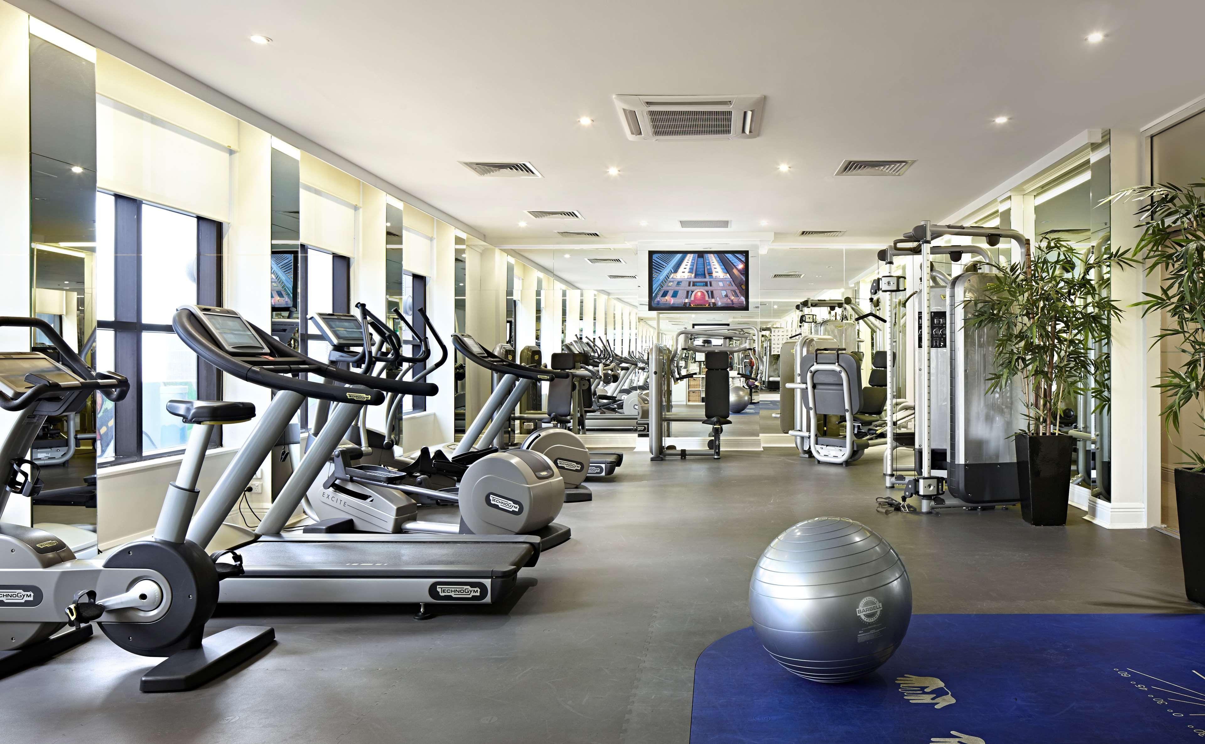 Stamford Plaza Melbourne Ξενοδοχείο Εξωτερικό φωτογραφία The photo shows a modern gym or fitness center. There are several exercise machines, including treadmills and elliptical trainers, positioned near large windows that allow natural light to flood the space. A television is mounted on the wall, likely 