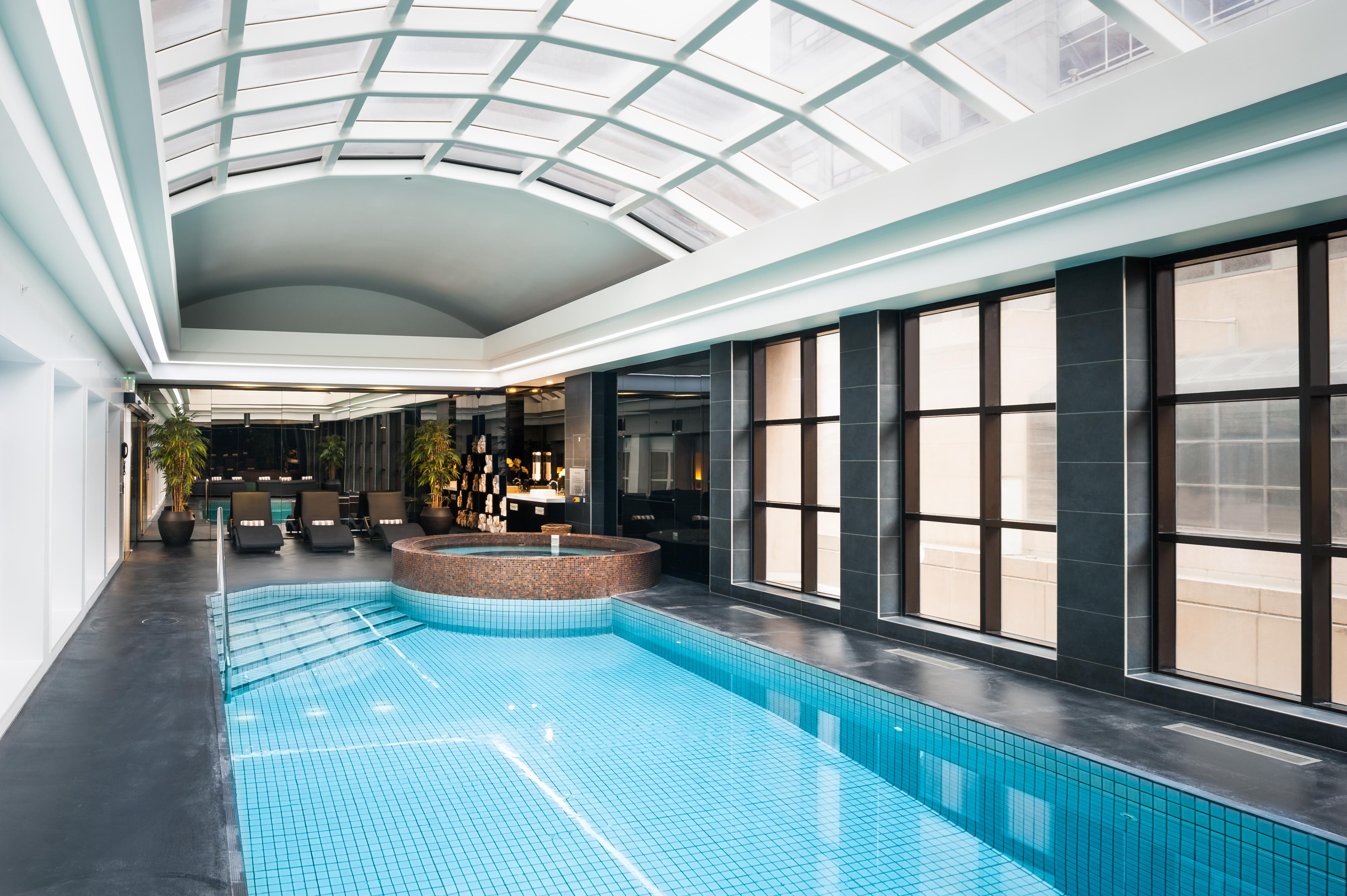 Stamford Plaza Melbourne Ξενοδοχείο Εξωτερικό φωτογραφία The photo shows an indoor swimming pool area with a modern and sleek design. The pool is rectangular and features bright blue tiles. Above the pool, there's a large, transparent glass ceiling that allows natural light to flood the space. Surrounding 