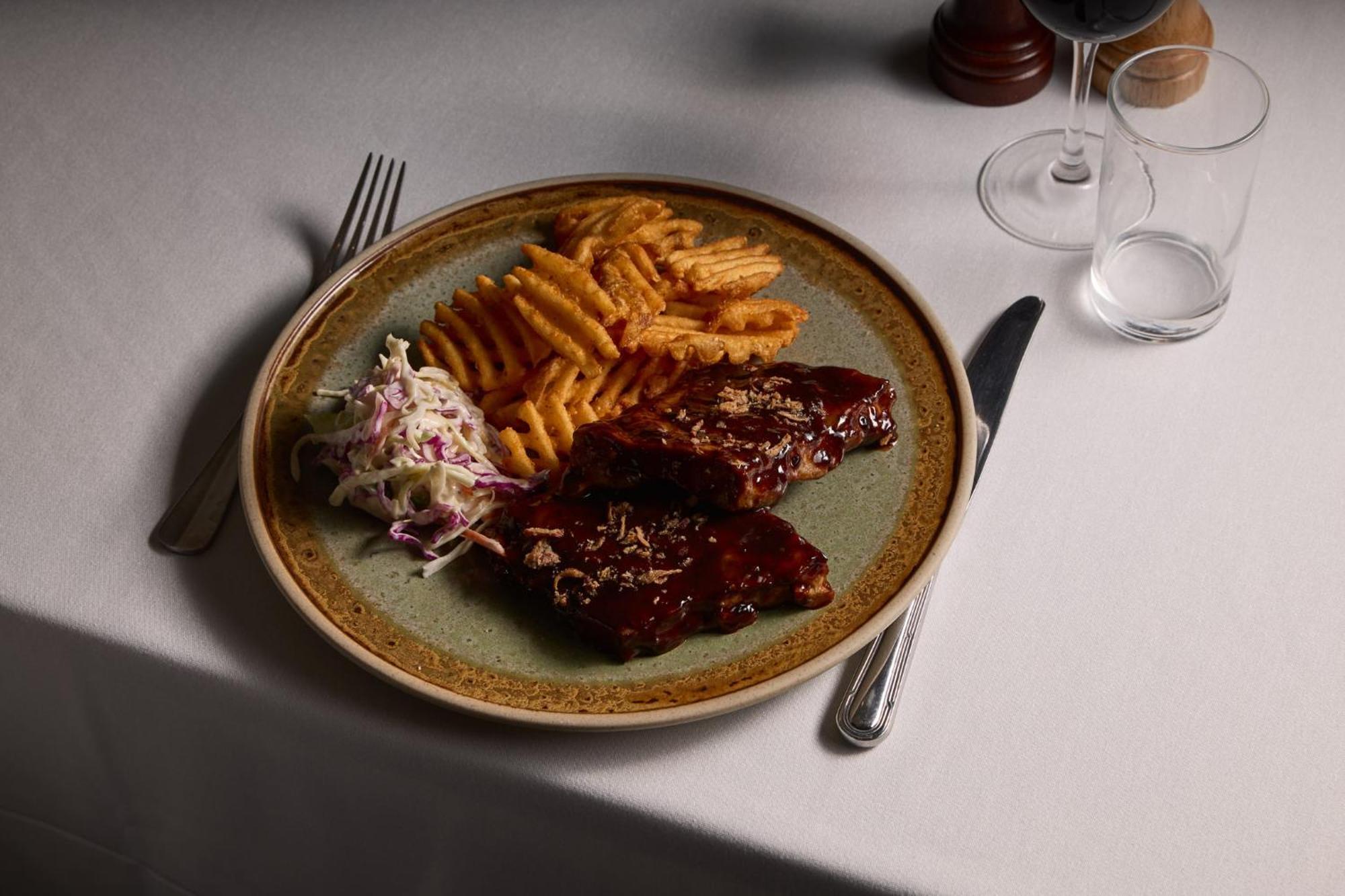 Stamford Plaza Melbourne Ξενοδοχείο Εξωτερικό φωτογραφία The photo displays a plate of food featuring two pieces of steak that appear to be glazed with a rich sauce. Alongside the steak, there are crinkle-cut fries arranged neatly on one side of the plate. Additionally, there's a small serving of coleslaw,