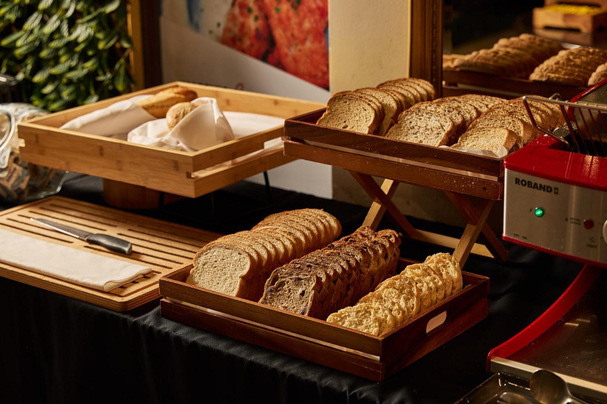Stamford Plaza Melbourne Ξενοδοχείο Εξωτερικό φωτογραφία The photo shows a display of various types of bread arranged on wooden trays. There are several stacks of sliced bread, including light and dark varieties. One tray appears to hold a selection of whole grain or multigrain bread, while another feature